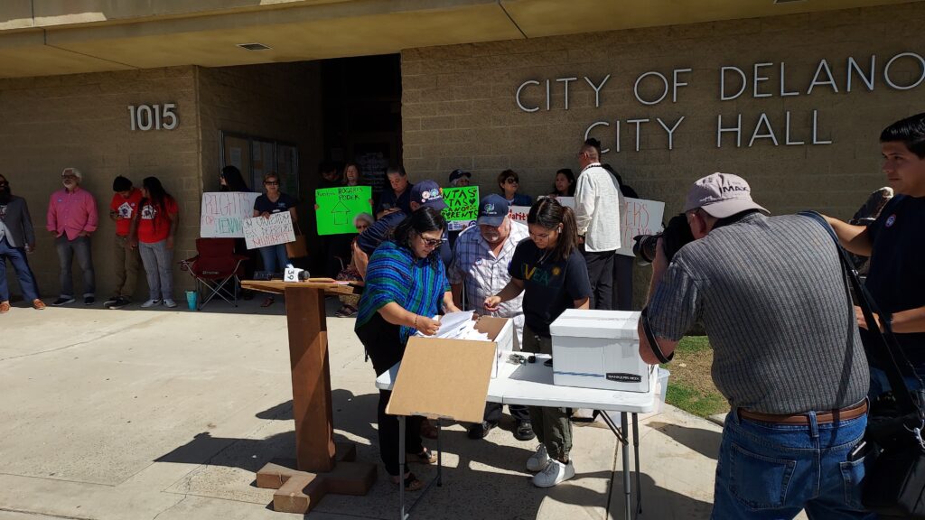 Proponents of rent control ordinance inspect petitions to be handed in to Delano city clerk office